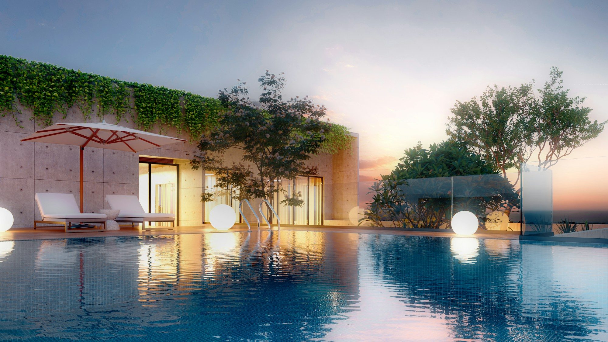 An infinity pool and lounge chairs facing the sea at sunset.